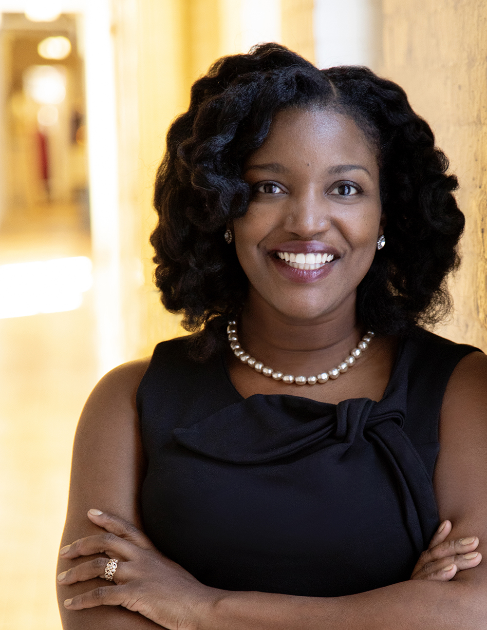 Shanelle Haile headshot; wearing a black sleeveless top with a neutral background