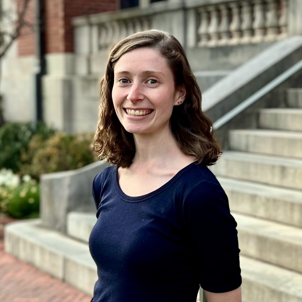Devanney Haruta, a Ph.D. candidate in musicology and ethnomusicology, smiling while looking at the camera, wearing a dark top.
