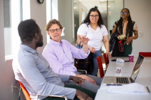 Urban Education Policy graduate students and faculty interacting together at a table.