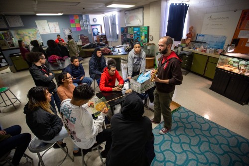 Doctoral student working with a diverse group of students in a classroom setting