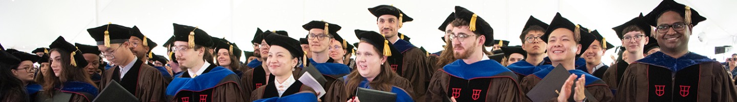 group of graduating students in regalia in a row standing