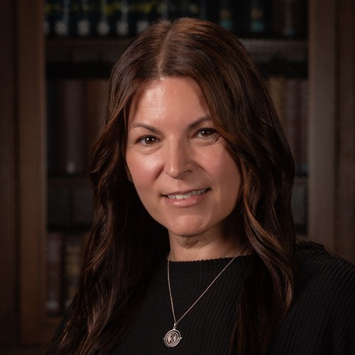 Michelle Rose in a dark shirt with a dark wood background